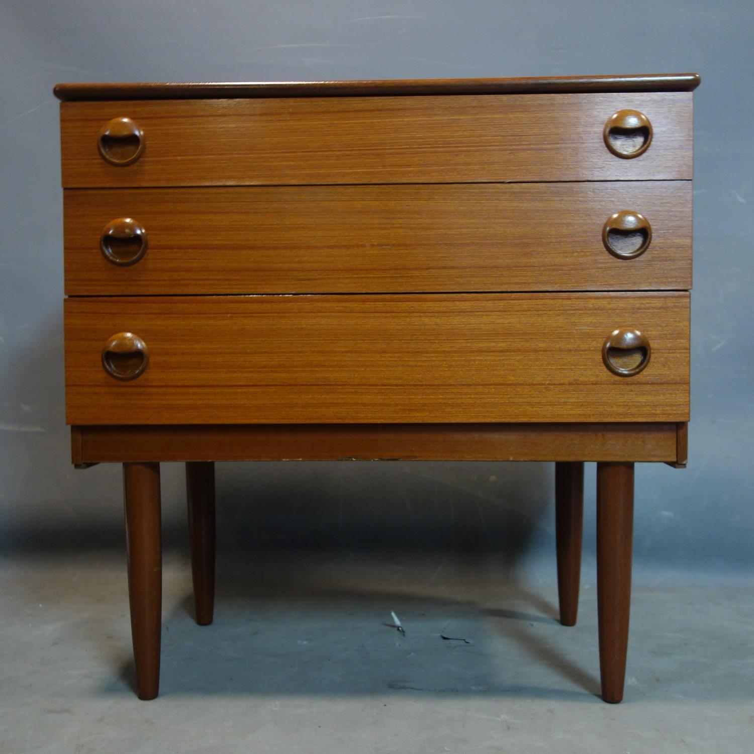 A teak chest of four long drawers, on tapering legs, H.74 W.75cm