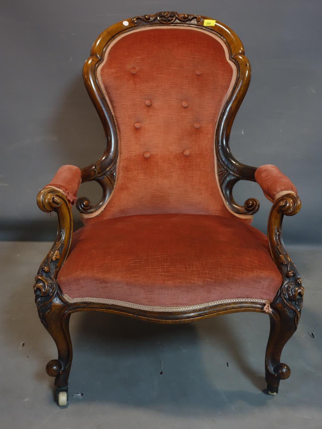 A Victorian mahogany spoon back armchair, with pink velour upholstery, raised on cabriole legs and