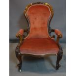 A Victorian mahogany spoon back armchair, with pink velour upholstery, raised on cabriole legs and