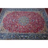 A large Persian Najafabad carpet, central floral medallion and floral motifs on a rouge field,