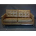 A Florence Knoll style tan leather sofa, raised on chrome base