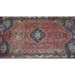 A large Persian carpet, with central diamond medallion, geometric motifs and horse head motifs on