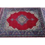 A Persian Tabriz carpet, central double pendant medallion on a rouge field, within floral borders,