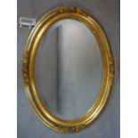 A 20th century oval gilt mirror, with bevelled glass plate and floral decorated frame, 72 x 54cm