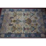 A Persian style carpet, flower and urn motifs on a cream ground, within blue floral border, 302 x