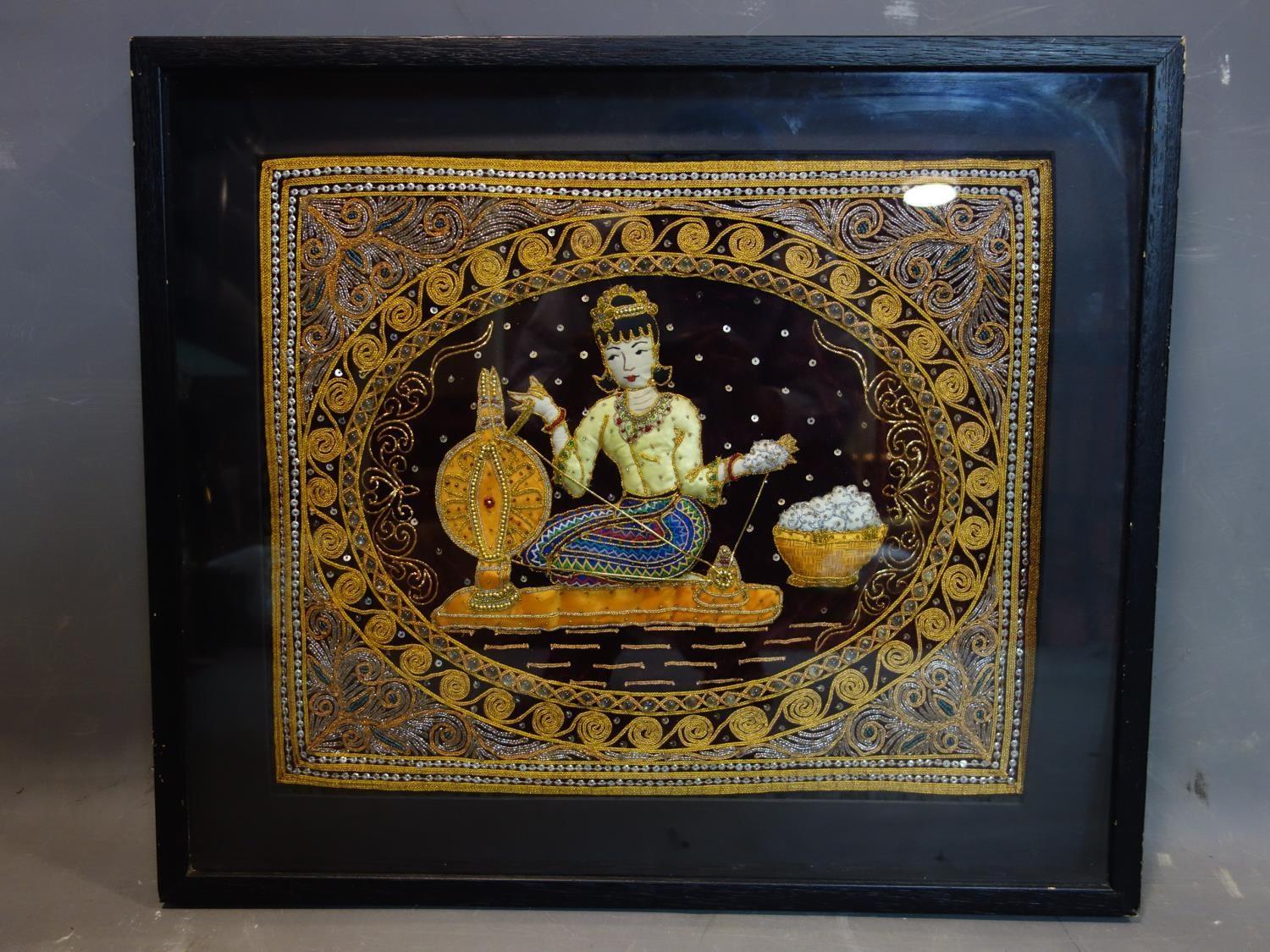 A Thai Kalaga textile depicting a seated lady spinning silk, in frame, 55 x 64cm - Image 2 of 2