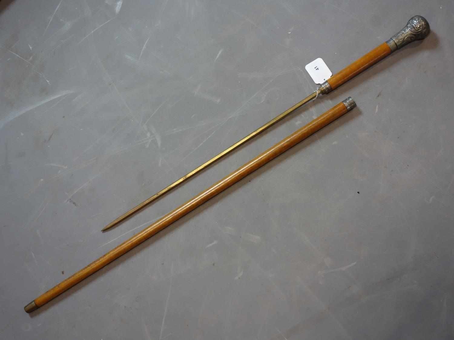 A vintage walking stick/fire poker with silver top and collar marked B.D.H, L.97cm