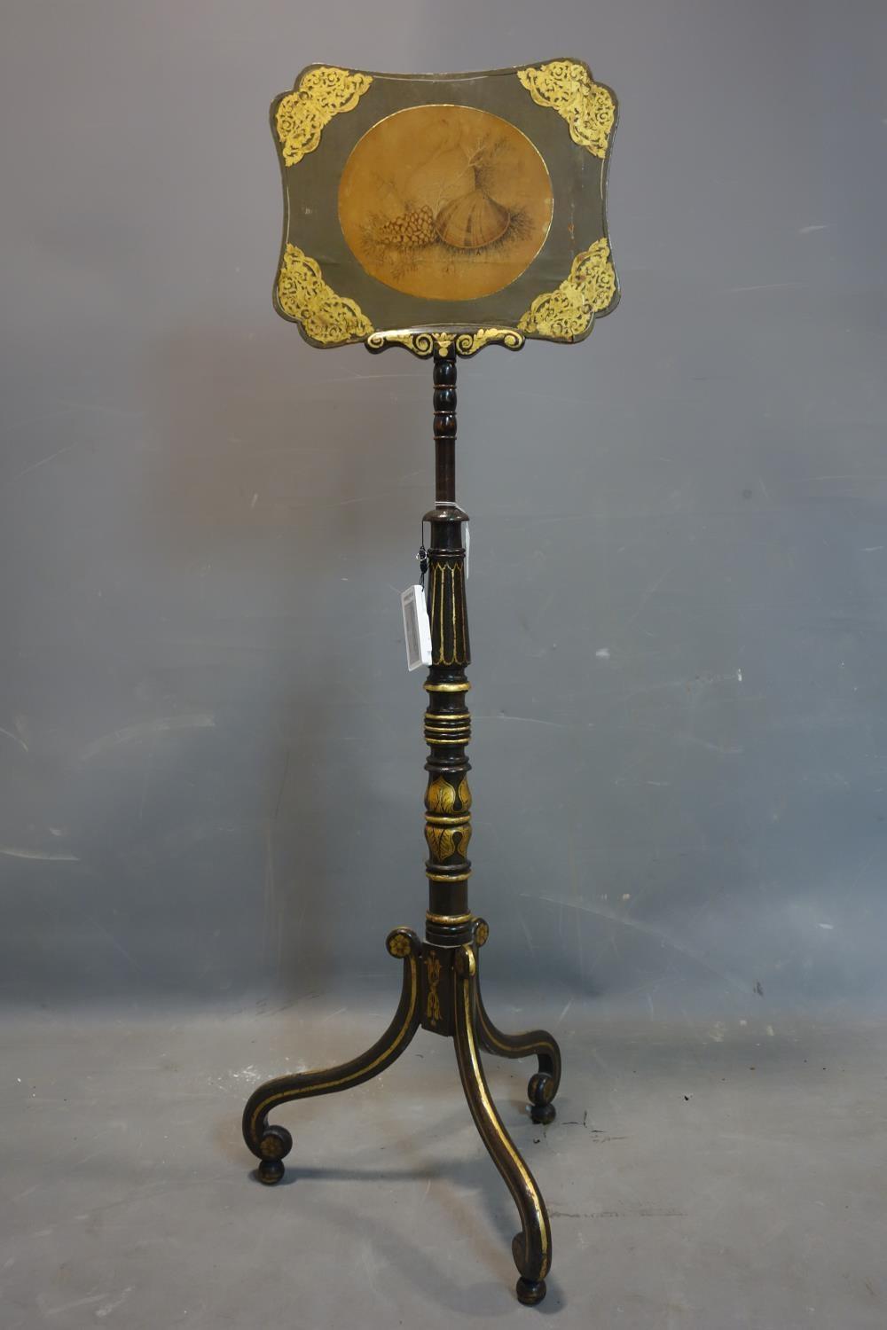 A late 19th/early 20th century ebonised and gilt painted adjustable fire guard, raised on 3 scroll