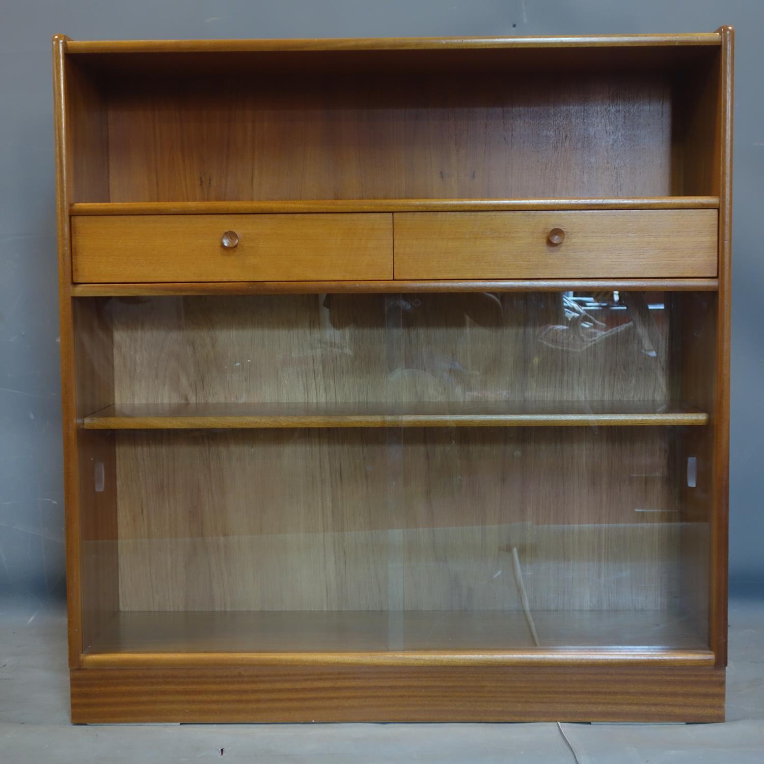 A 20th century teak bookcase with 2 drawers and 2 sliding glass doors, label for Nathan, H.108 W.102