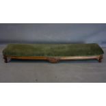 A Victorian carved walnut footstool with green velvet upholstery, on cabriole legs, H.19 W.123 D.