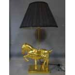 A gilt painted metal horse table lamp, with black shade, H.82cm