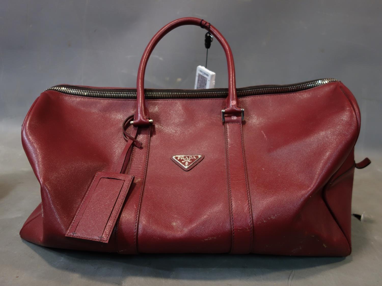 A Prada burgundy leather holdall bag. L.50cm