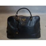 A Prada black leather handbag with dust cover
