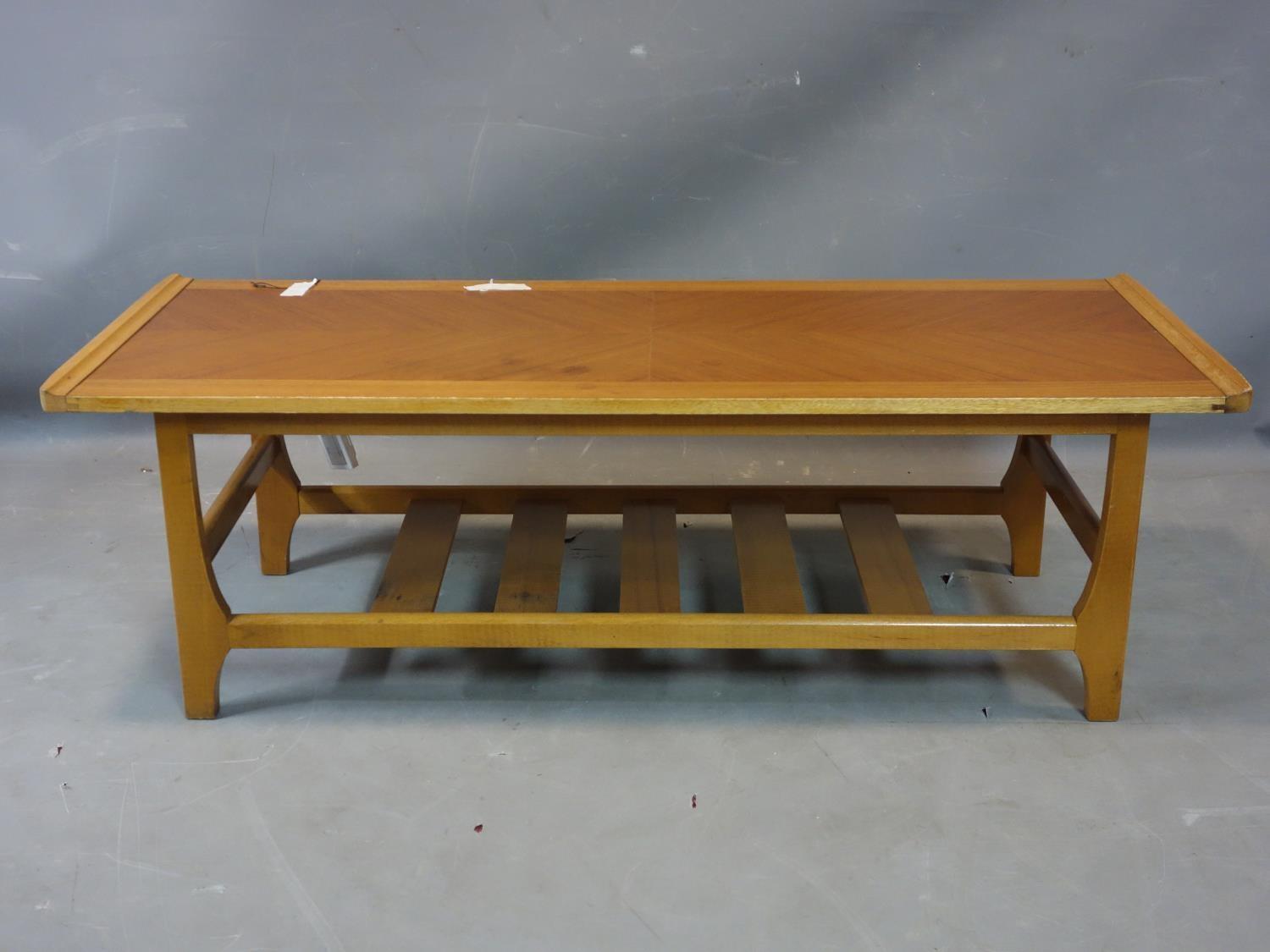 A teak coffee table, with undertier rack, H.35 W.111 D.46cm