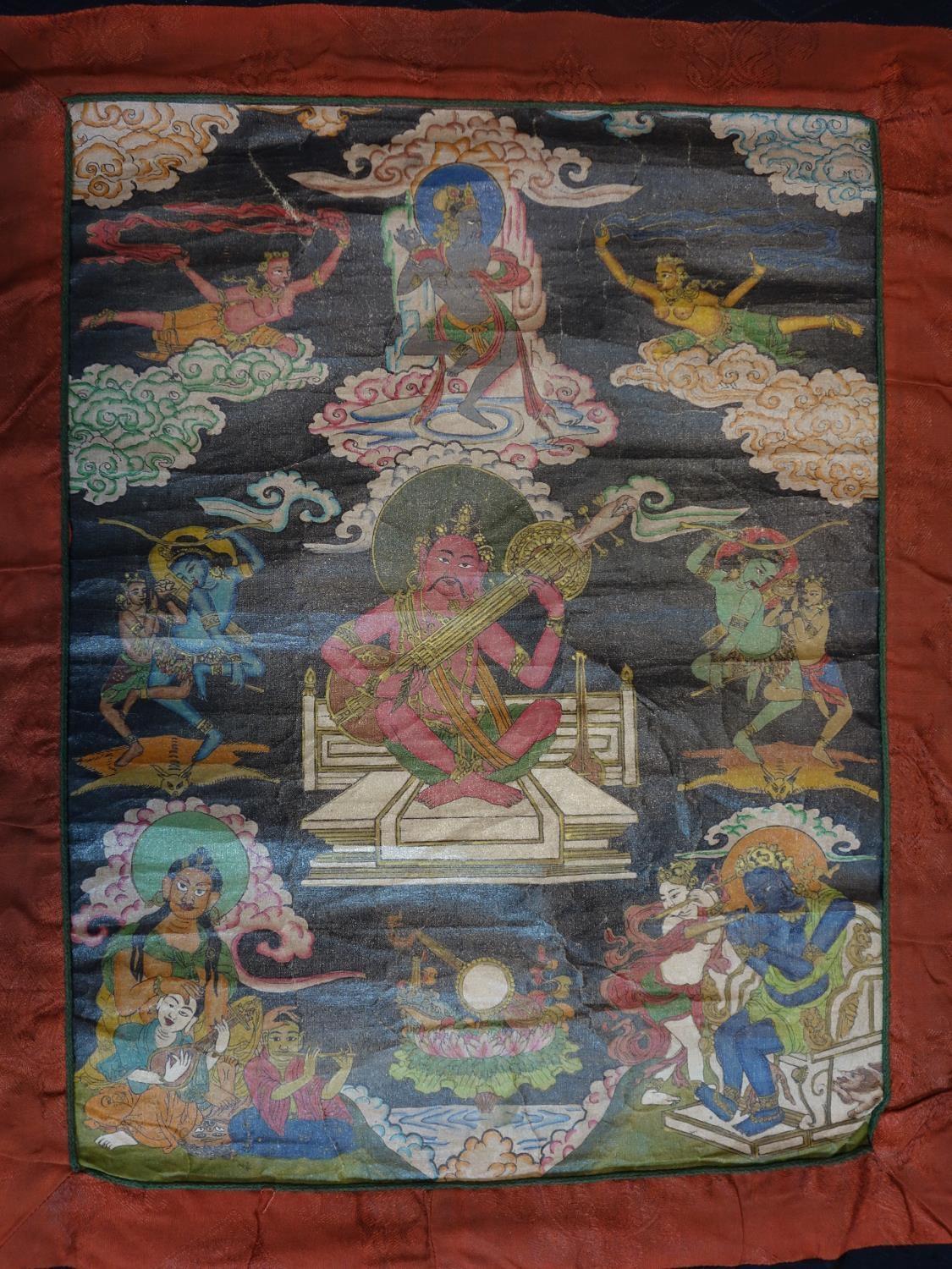 A hand-painted Tibetan Thangka depicting a deity in a landscape scene with animals, having script to - Image 2 of 7
