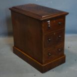 A mahogany pedestal chest of three drawers, with quarter veneered and moulded top, raised on
