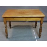 A 20th century pine kitchen table, with single drawer to end, raised on turned legs, H.77 W.122 D.
