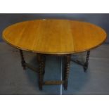 A 20th century oak drop leaf table, with barley twist supports, H.72 W.144 D.104cm