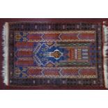 A Persian prayer rug with central geometric vase motif, on a blue ground, contained by geometric
