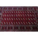 A North East Persian Turkoman Carpet, the repeating stylised goul motifs, on a rouge field,