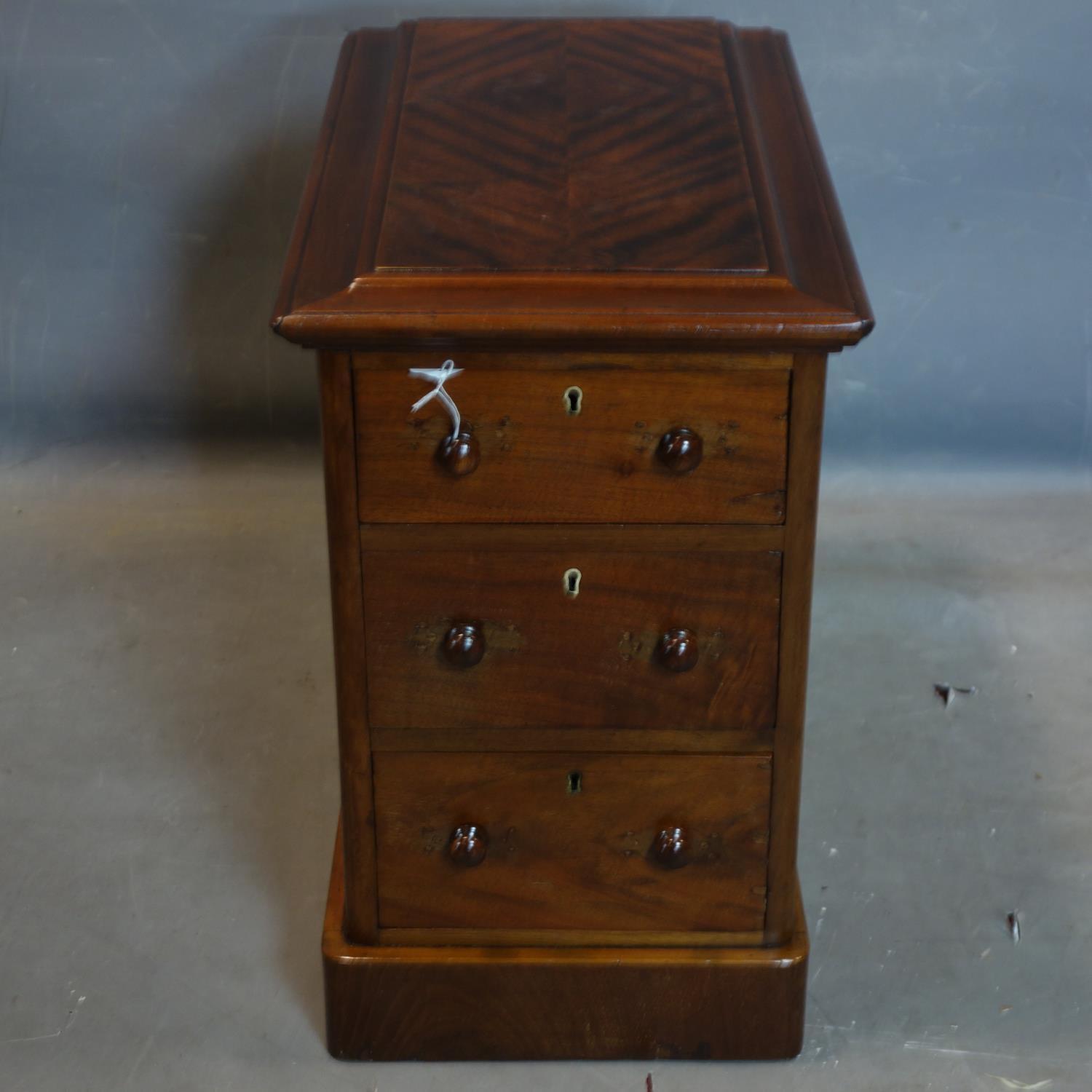 A mahogany pedestal chest of three drawers, with quarter veneered and moulded top, raised on - Image 2 of 2
