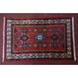 An Iranian Rug with geometric designs on a red ground, 118 x 74cm