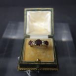 A 9ct yellow gold, three stone ruby and seed pearl set ring, hallmarked, size R, in associated case