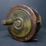 A vintage hardwood and brass freshwater fishing reel with full line, Diameter 12cm