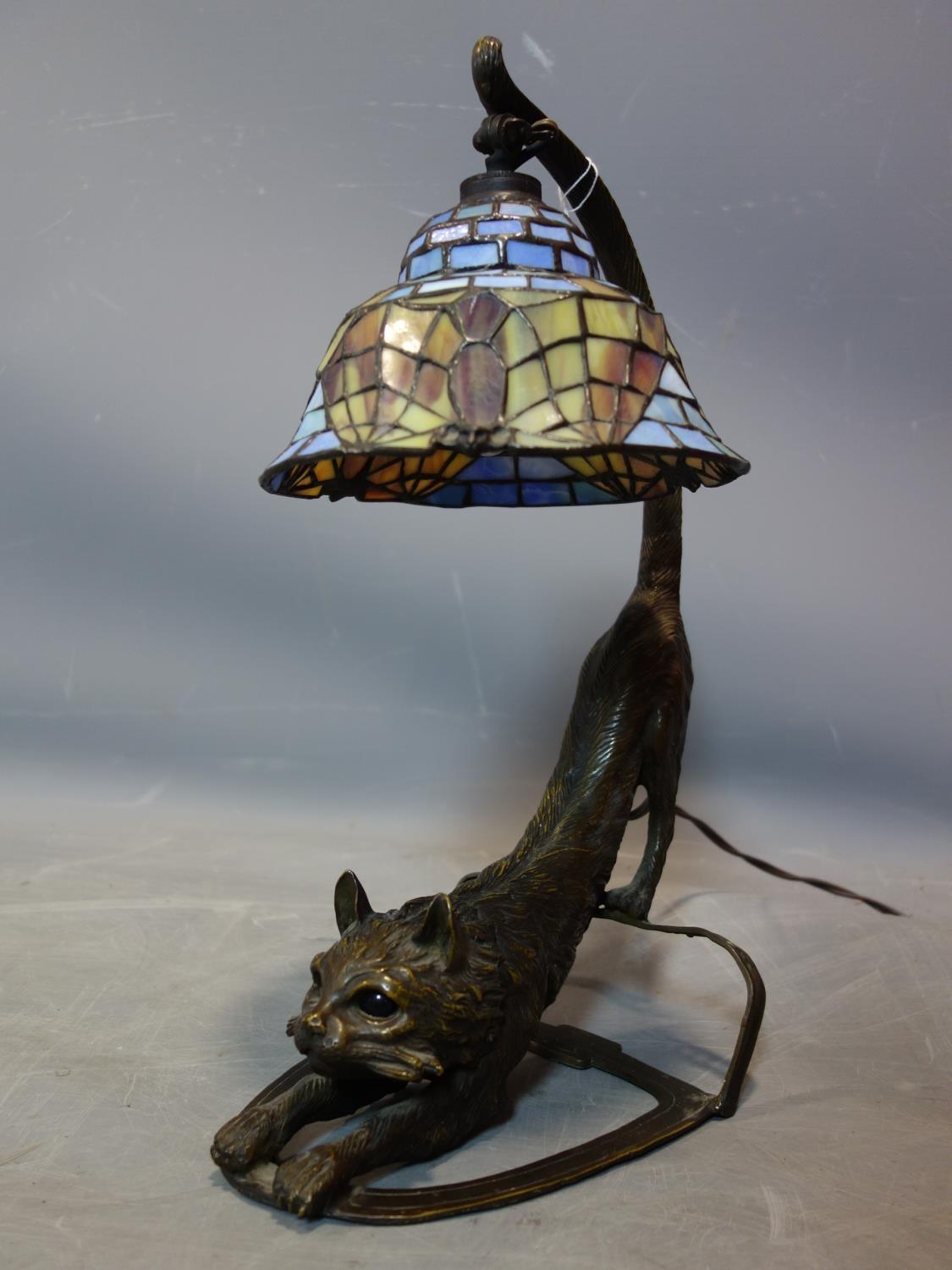 A Tiffany style lamp, the base in the form of a bronze out stretched cat, H.43cm
