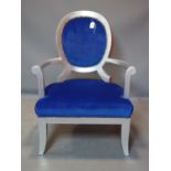A contemporary silvered armchair with blue velour upholstery