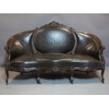 A late 19th/early 20th century French carved mahogany sofa, with studded leather upholstery,