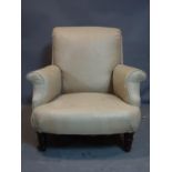 A late 19th/early 20th century armchair, raised on turned oak legs and castors