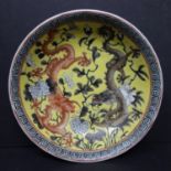 A Chinese Republic period dish, decorated with dragons and flowers in grisaille and red on a