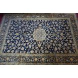 A Persian Kashan carpet the central floral medallion surrounded by floral swags and motifs, on a