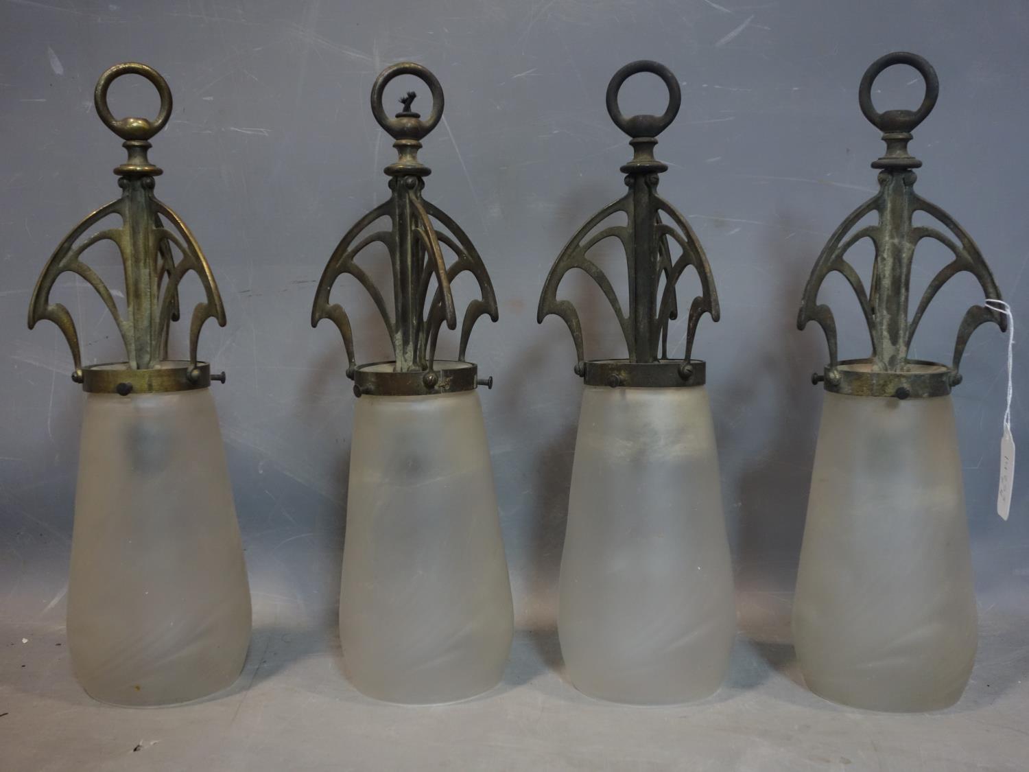 A set of four Art Nouveau ceiling lights with stylised supports and frosted glass shades, H.40cm (4)