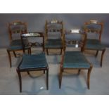 A set of four Regency mahogany dining chairs, with brass inlay, raised on sabre legs, together