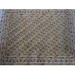A Soumak Suzani carpet with repeatin geometric diamond motifs, on a beige ground, contained by