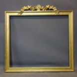 A gilt wood picture frame with bow crest, 97 x 99cm outer frame, 77 x 88cm inner frame