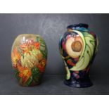 A Moorcroft vase with fruit design on a blue ground dated 2000, H.16cm, together with one other with