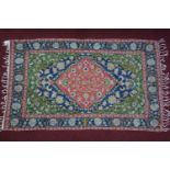 An Indian embroidered tapestry, central diamond medallion on a blue ground within floral borders and