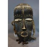 A West African tribal mask from the Dan / Bete peoples of Ivory Coast / Liberia, wooden with brass