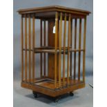 An Edwardian Sheraton revival inlaid mahogany revolving bookcase, H.77 W.47 D.47cm