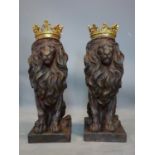 A pair of fibreglass models of seated lions with gilt crowns, H.56cm