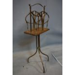 An Art Nouveau brass and oak revolving magazine rack, H.80cm