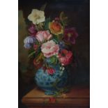 A late 19th/early 20th century oil on panel of flowers in a blue and white pot, set in ornate gilt