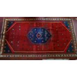 A vintage Persian rug, geometric design, red ground, 253 x 150cm