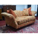 A Victorian style camel back sofa, raised on turned legs and castors. 212cm L x 85cm H x 100cm W