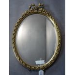 An oval gilt mirror with ribbon finial and bevelled glass plate, on easel support, H.55 W.40cm