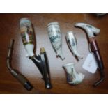 A collection of five 19th century German porcelain smoking pipes, hand painted, together with 3 horn