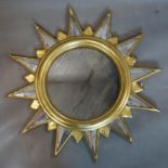 A giltwood star design mirror, with ghosted circular glass plate, the rays with mirrored glass